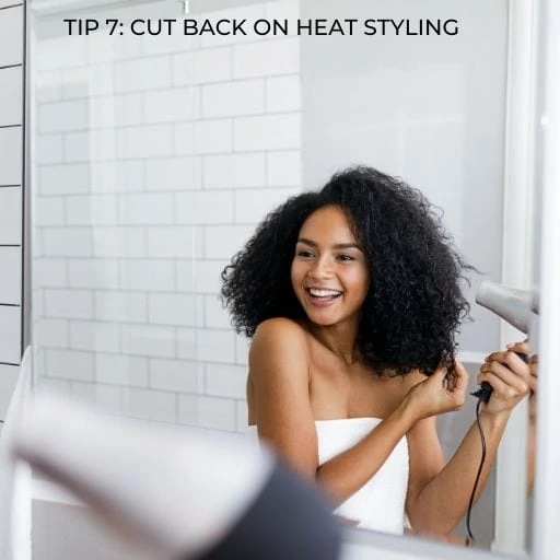 women blow drying her hair with text overlay - tip cut back on heat styling