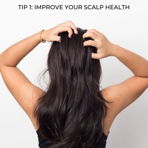 woman rubbing her scalp with text overlay - tip improve your scalp health