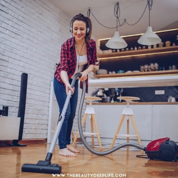 woman listening to an audiobook while cleaning the house