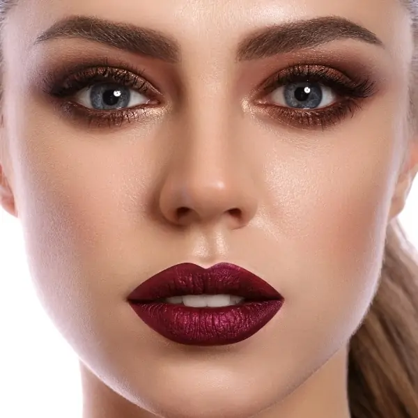 woman with a fall makeup look that features metallic burgundy lips