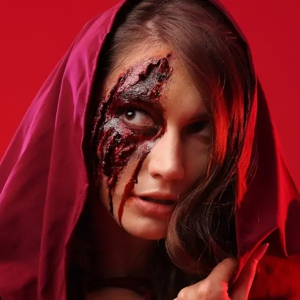 woman dressed as little red riding hoof for halloween with gory special effects makeup