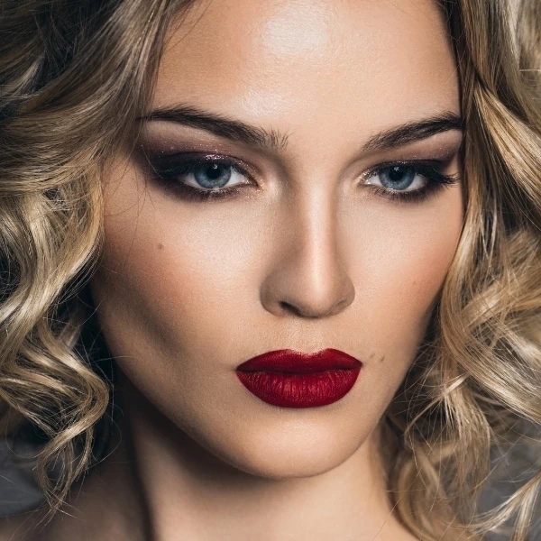 woman with a fall makeup look wearing a dark red lipstick and smokey eyes