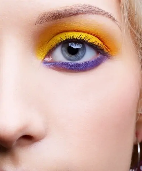 woman with blue eyes and a eyeshadow look that uses yellow and purple