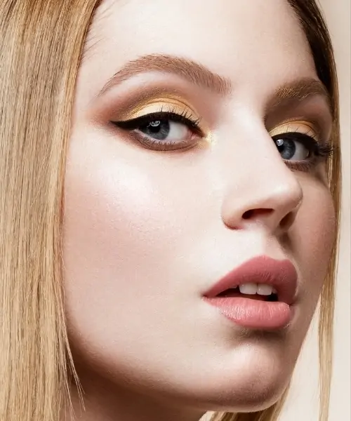 woman with brown and gold eyeshadow look for her blue eyes