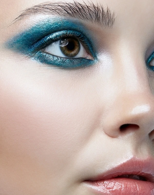 woman with eye makeup featuring a blue eyeshadow look for her brown eyes