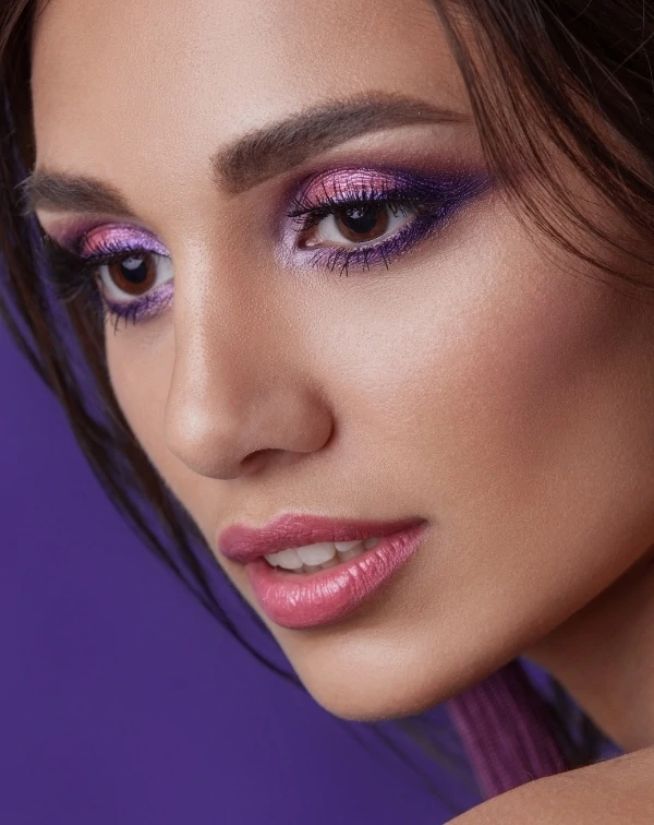 woman with brown eyes and purple eye makeup look using eyeshadow