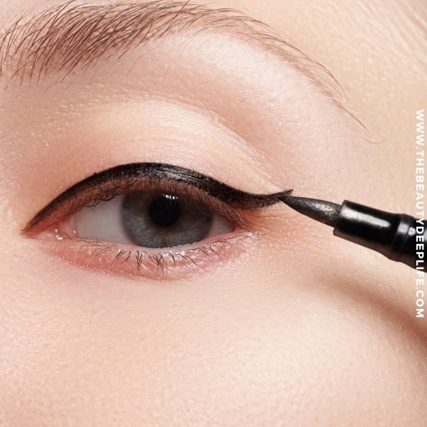 woman's eye while she's applying liquid eyeliner