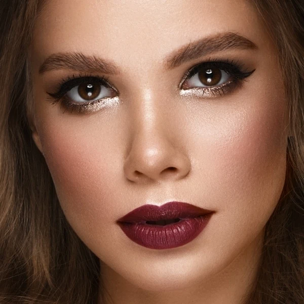 woman with a fall makeup look featuring burgundy lipstick