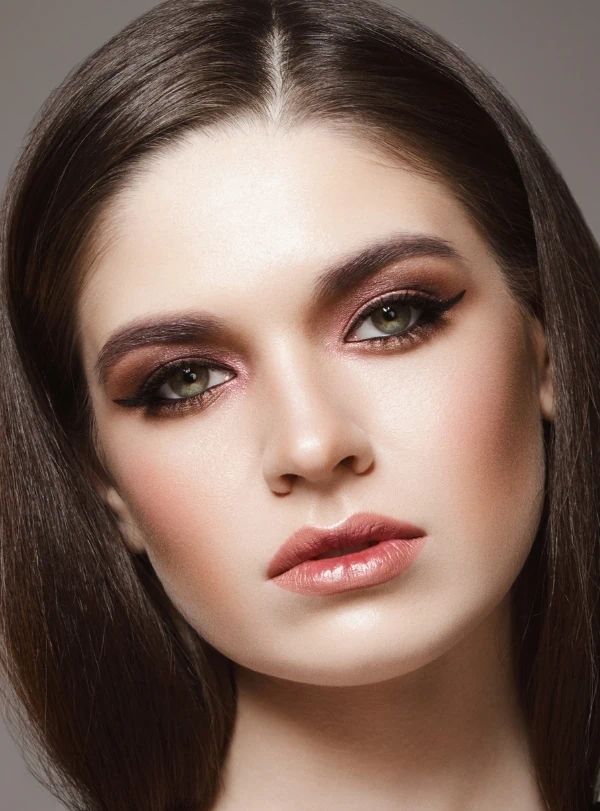woman wit a beautiful makeup look for green eyes using a cat-eye and a berry colored eyeshadow