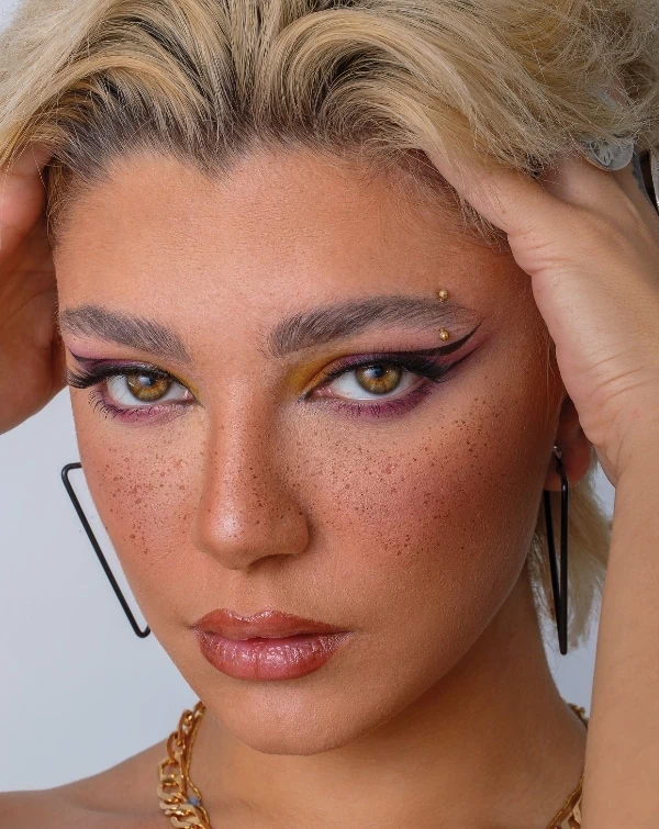 woman with a magenta eyeshadow look and winged eyeliner