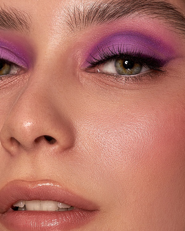 woman with green eyes and a pink with purple eyeshadow look