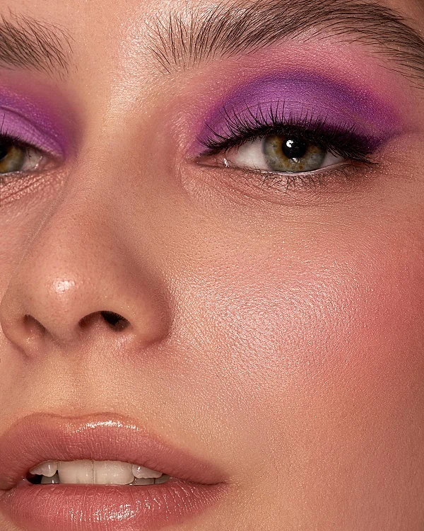 woman with green eyes and a pink with purple eyeshadow look