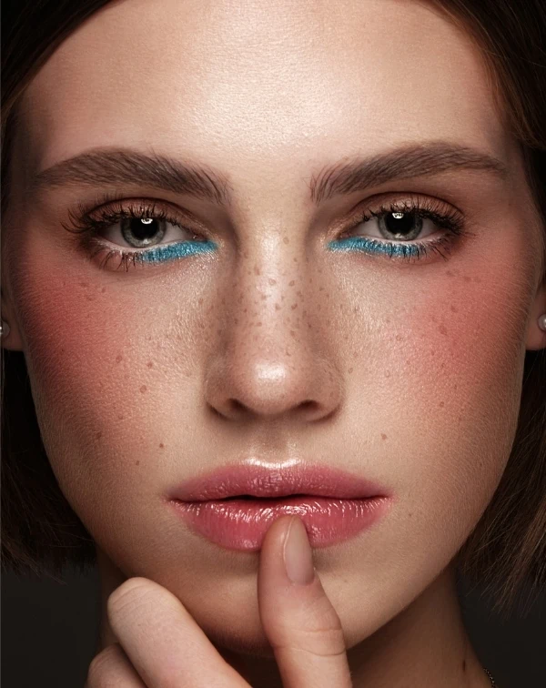 woman with a simple eyeshadow makeup look using blue eye makeup