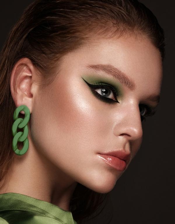 woman with green eyeshadow look and cat-eye makeup