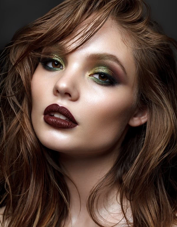 woman with a green eyeshadow look and dark lipstick