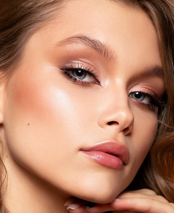 woman with blue eyes and a champagne pink with rose gold eyeshadow look