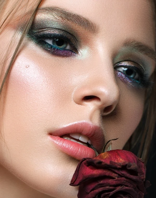 Woman with blue eyes and a green and purple eyeshadow look