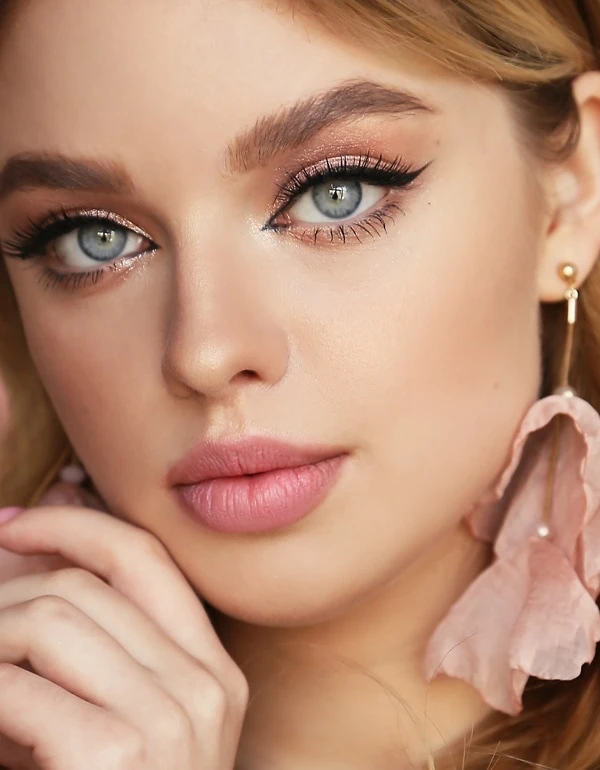 woman with blue eyes and a soft gold with pink eyeshadow look
