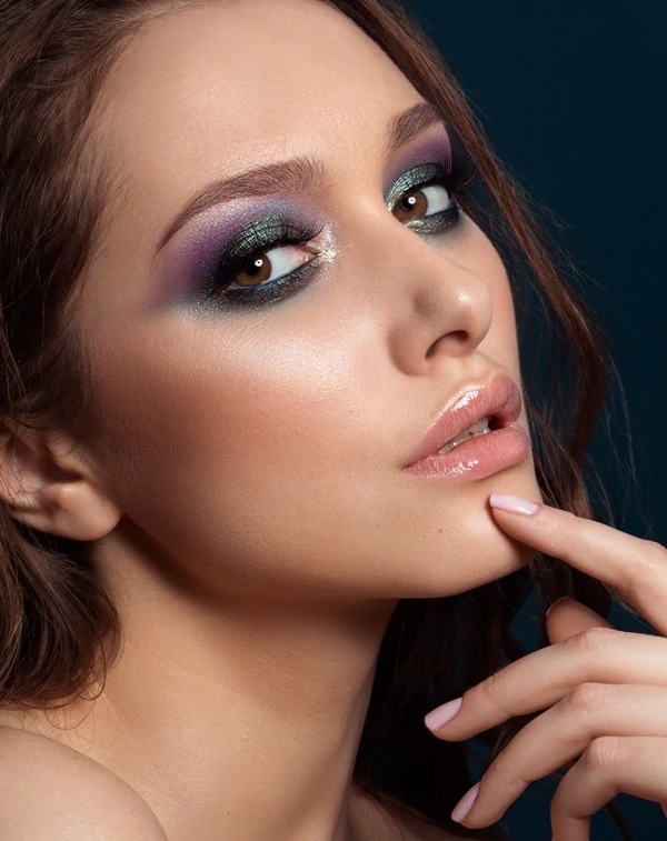 woman with brown eyes and a purple and green eyeshadow makeup look