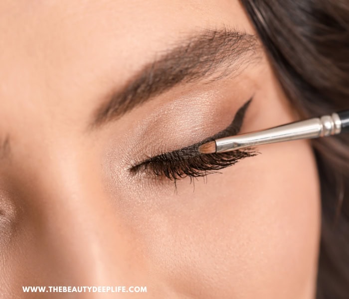 woman applying gel liner with a brush