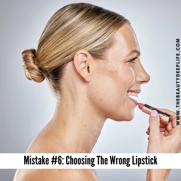 Middle aged woman applying lipstick makeup