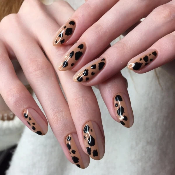 female hands with leopard nail art on half of her nails