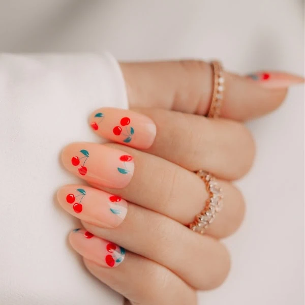 female hand with cherry nail design