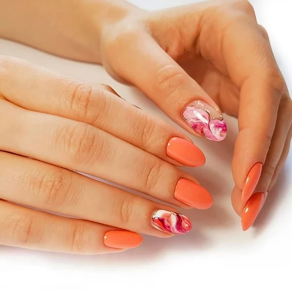 female hands with bright marble nails and orange polish