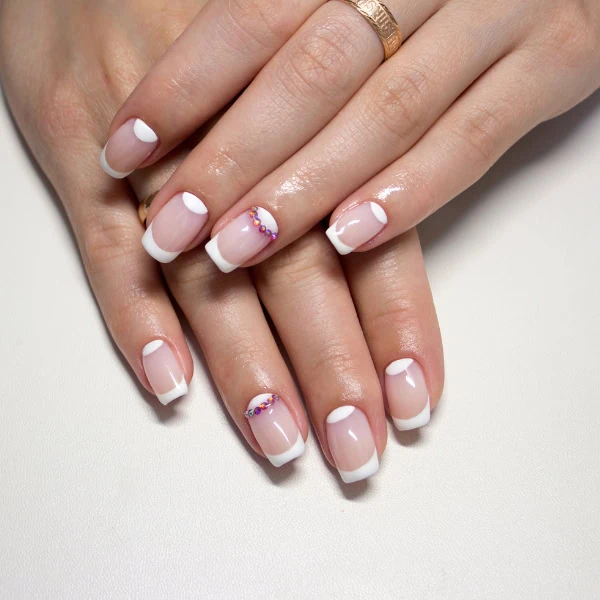 female hands with french manicure with diamonds