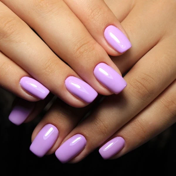 female hands with pastel purple nails