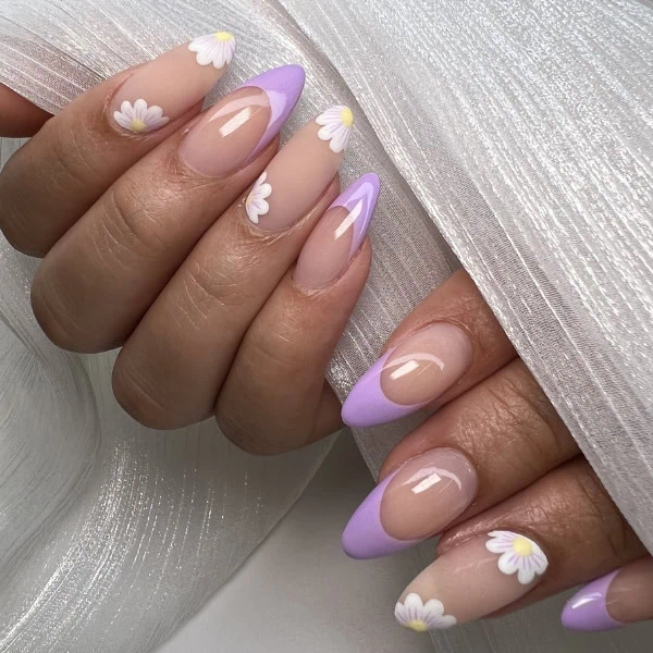 female hands with purple french tips on nails and white flowers