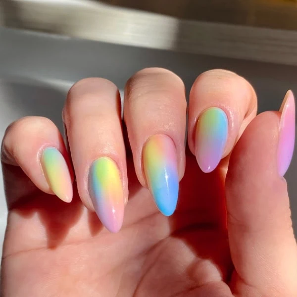 female hand with rainbow ombre nails