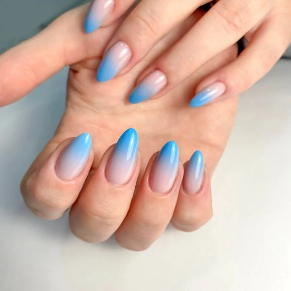 female hands with blue ombre nails