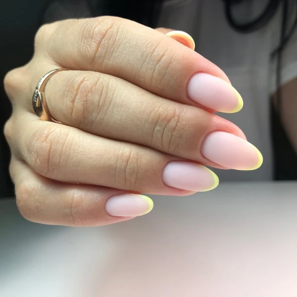 female hand with simple manicure using yellow nail tips