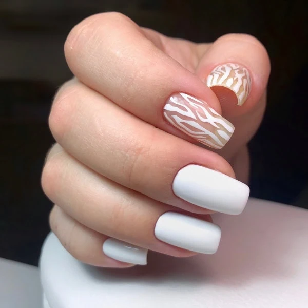 female hand with white nails and zebra animal print design