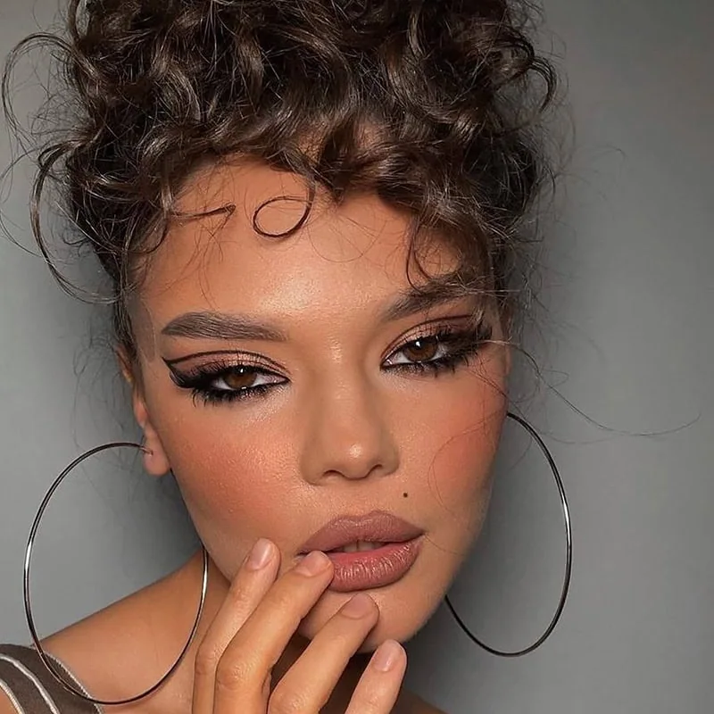 beautiful woman with graphic eyeliner makeup and doll blush trend for fall