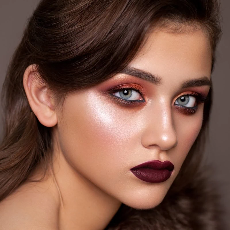 Woman with fall makeup featuring vampy lips and orange eyeshadow