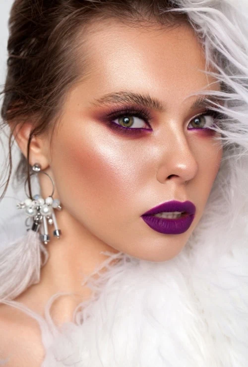 woman with green eyes and red and purple eyeshadow makeup look