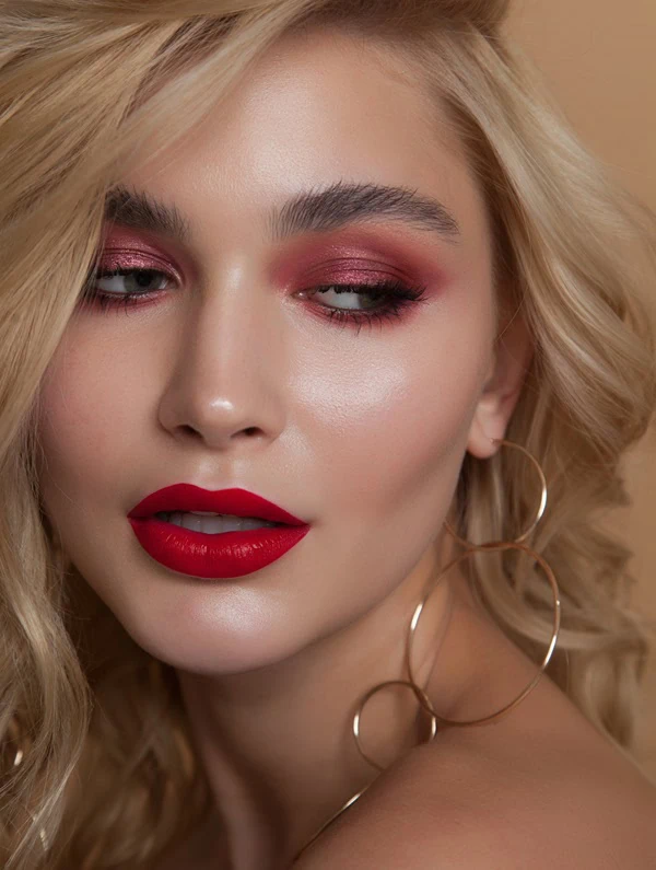 woman with a beautiful christmas makeup look for the holidays featuring red lips and cranberry eyeshadow