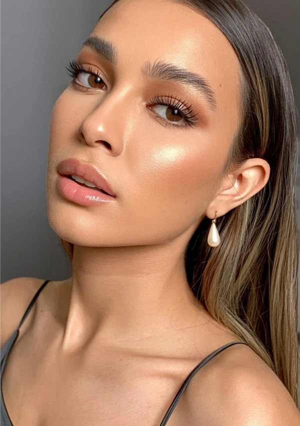 Close-up portrait of a young woman with flawless glowing skin, soft makeup, and pearl earring, showcasing beauty skincare, makeup, and elegance.