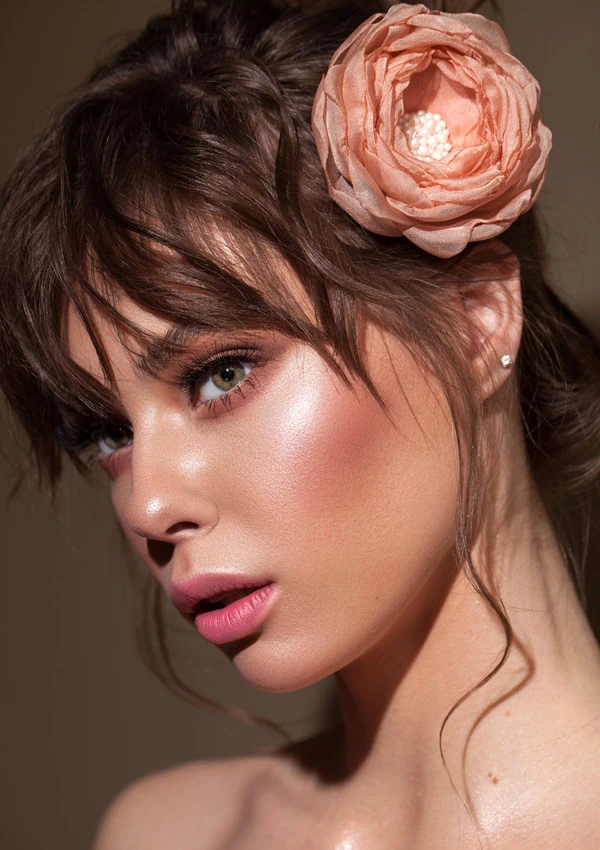 woman with beautiful green eyes and rosy blush makeup with glowing skin for spring