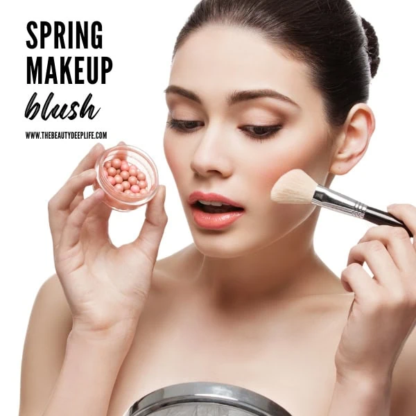 woman putting on blush makeup for spring