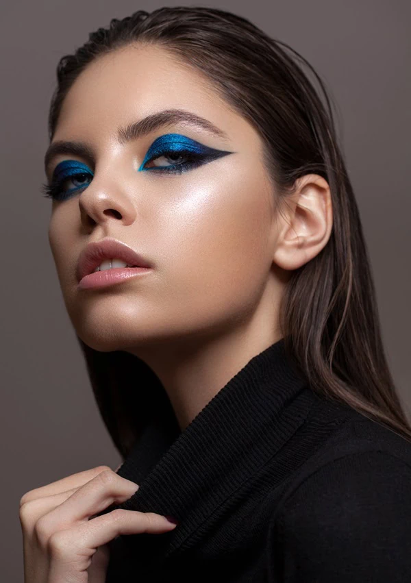 woman with a colorful blue graohic eye makeup look