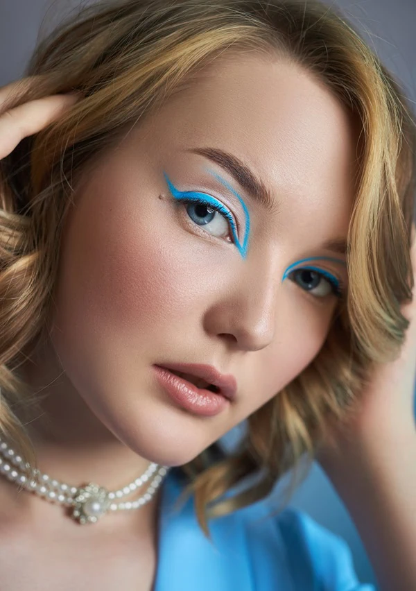 woman with blue eyes and graphic colorful blue eye makeup