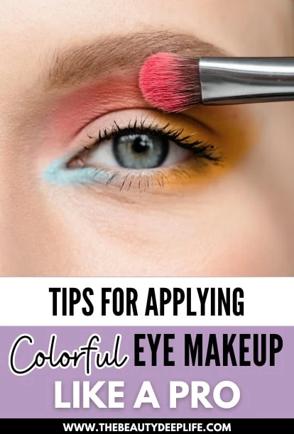 closeup of a young woman applying bright colorful eye makeup to one eye