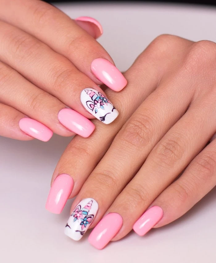 pink nail ideas with one white nail that has unicorn painted on it for spring