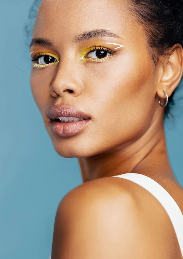 woman with a colorful sunset eye makeup look using yellow and orange