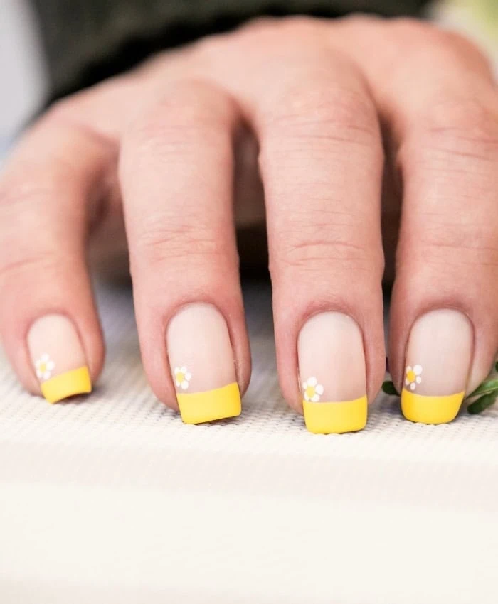 yellow spring nails with daisies painted on them