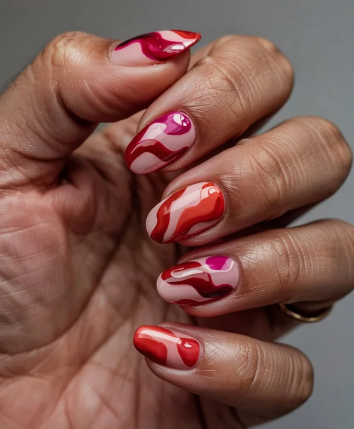 hand with marbled looking red and pink nails