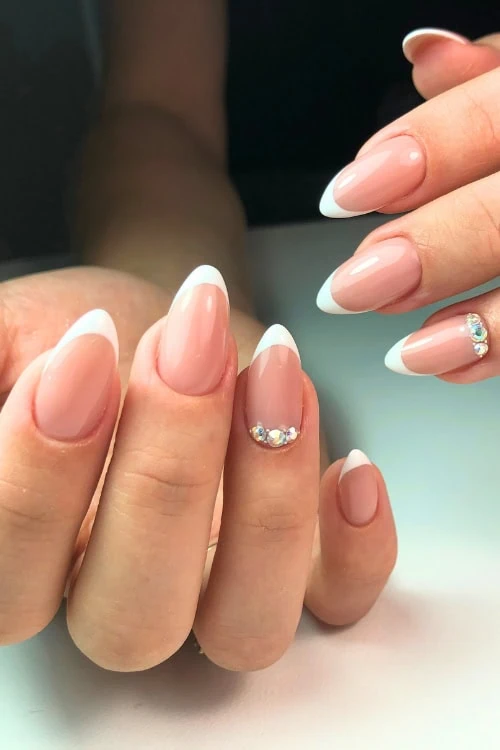 female hand with french manicure and rhinestone cuffs